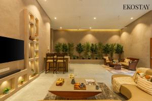 a living room with a couch and a tv at EKOSTAY - The Clay House in Alibaug