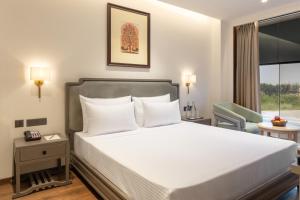 a hotel room with a bed and a chair at Clarks Inn Kharar-Mohali in Kharar +24 photos