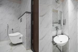 a white bathroom with a sink and a toilet at FabHotel Eraya in Varanasi