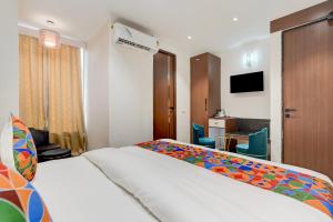 a hotel room with a bed and a desk at FabHotel Eraya in Varanasi