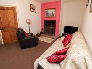 Wayside Cottage في نيوتون باي ذا سي: غرفة معيشة مع أريكة ومدفأة