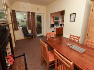 Wayside Cottage في نيوتون باي ذا سي: مطبخ وغرفة طعام مع طاولة وكراسي خشبية