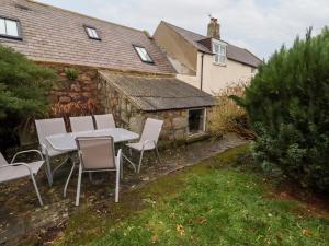 Wayside Cottage في نيوتون باي ذا سي: طاولة وكراسي في ساحة منزل