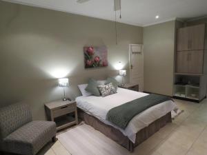 a bedroom with a bed and a chair in it at Home on Haven Hill in Durban