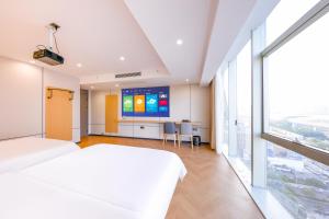 a hotel room with a large bed and a flat screen tv at Prime Pazhou Aparthotel - Pazhou Station Line 8 and 11 - Steps away from Canton Exhibition Center in Guangzhou
