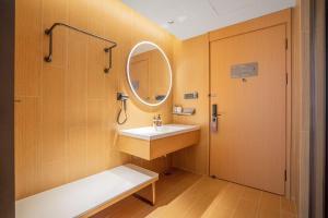 ein Badezimmer mit Waschbecken und Spiegel in der Unterkunft JI Hotel Chongqing Yufu Industrial Park TuoXinXing Times in Chongqing