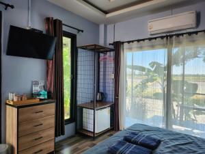 a bedroom with a bed and a tv and a window at Maderlar Farm Restaurant & Resort in Ban Kao Lieo +59 photos