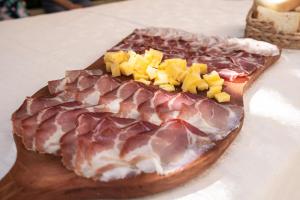 a piece of meat and cheese on a cutting board at Holiday Home Pr'Lukčevih with 4 Bedrooms & Sauna in Kanal +40 photos