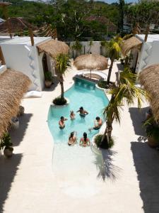 een groep mensen in een zwembad in een resort bij Luna Kai Villas in Uluwatu