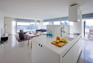 a white kitchen with a counter with fruit on it at Urban Residences Rotterdam in Rotterdam