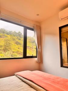 a bedroom with a bed and a large window at Cozy Hostel and Tours in Ha Giang