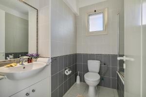 a bathroom with a toilet and a sink at Kastalia Springs 3bd VIilla in Peiya by VICHY Holidays in Peyia +28 photos