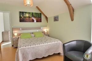 ein Schlafzimmer mit einem Bett und einem Stuhl in der Unterkunft Beau soleil in Aucaleuc