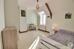 a bedroom with a bed and a table and a window at Beau soleil in Corseul