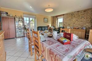 ein Esszimmer mit einem Tisch und einem Tischtuch in der Unterkunft Beau soleil in Aucaleuc