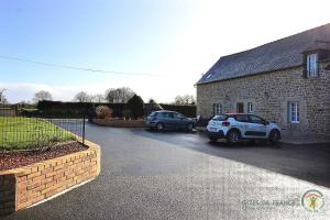 two cars parked in front of a brick building at Beau soleil in Corseul +6 photos