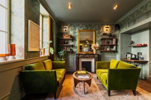 a living room with two green couches and a fireplace at Le Grand Quartier in Paris