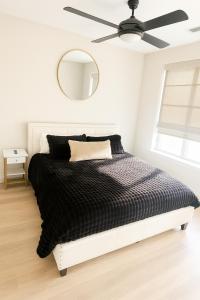 a bedroom with a black and white bed with a ceiling fan at The Deep Ellum Serenity Suite in Dallas