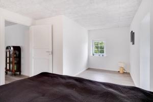a white room with a bed and a window at Villa Surrounded By Nature in Vissenbjerg