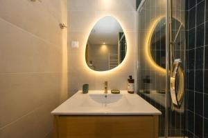 une salle de bains avec un lavabo et un miroir dans l'établissement Juliette Signature Studio - T1 de 25m2 - Centre-ville de Saint-Denis, à Saint-Denis