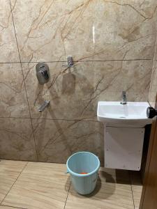 a bathroom with a sink and a bucket at Nestdormitory in Cochin
