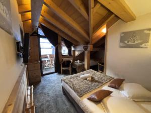a bedroom with a large bed in a room at Hôtel Les Airelles in La Clusaz