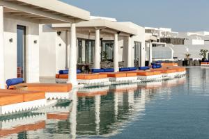 a pool at a resort with orange and blue chairs at Cresanto Luxury Suites in Imerovigli
