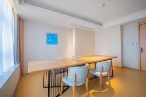 ein Esszimmer mit einem Holztisch und 2 Stühlen in der Unterkunft JI Hotel Chongqing Yufu Industrial Park TuoXinXing Times in Chongqing + 33 Fotos