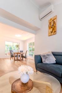a living room with a blue couch and a table at The Nature Nook in Upper Mudgeeraba