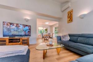 a living room with a blue couch and a tv at The Nature Nook in Upper Mudgeeraba