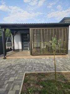 a house with a wooden deck and a tree at Áron Apartman in Tiszafüred