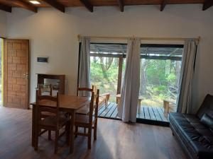 a living room with a wooden table and a couch at AIRES DEL BOSQUE Con JACUZZI in Punta Del Diablo