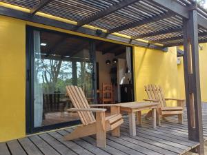 a patio with two chairs and a table on a deck at AIRES DEL BOSQUE Con JACUZZI in Punta Del Diablo