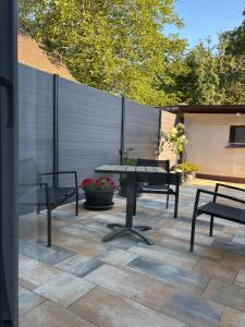 Un patio con bancos y una mesa y una valla. en Fewo Hommage, en Spremberg