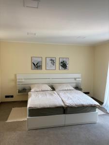 Un dormitorio con una cama con tres cuadros en la pared. en Fewo Hommage, en Spremberg