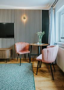 a living room with two chairs and a table at Willa przy Krupówkach Apartments & Rooms Villa Heart of the Mountains Zakopane in Zakopane +132 photos