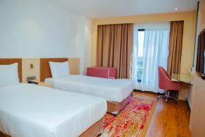 Buddha Regency Hotel في Gautam Buddha International Airport: غرفة فندقية بسريرين ونافذة +22 صورة