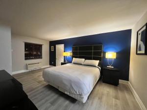 een slaapkamer met een groot bed met een blauwe muur bij Boardwalk Suites Lafayette in Lafayette