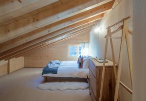 a bedroom with a bed in a room with wooden ceilings at Chalet Aberot in Wengen