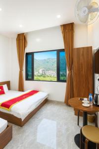 a hotel room with a bed and a table at Khách sạn Đức Phúc in Dồng Văn