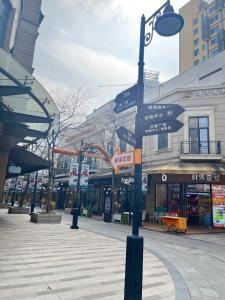 een straatpaal met straatnaamborden op een stadsstraat bij Orange Hotel Suzhou Emerald Plaza in Suzhou