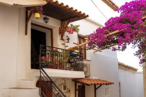 a white building with pink flowers on a balcony at Bougainvillea in Andros