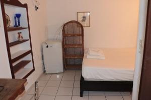 a small room with a bed and a small refrigerator at Bougainvillea in Andros