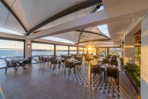 a restaurant with tables and chairs and a view of the ocean at Kefaluka Resort in Akyarlar