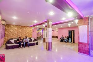 a group of people sitting on couches in a lobby at FabHotel Prime Rockstar Suites in Kolkata