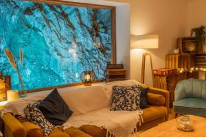 L'Estagnole pour 2 personnes, jacuzzi, hammam في إستين: غرفة معيشة بها أريكة و لوحة كبيرة