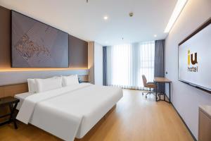 En eller flere senge i et værelse på Iu Hotel