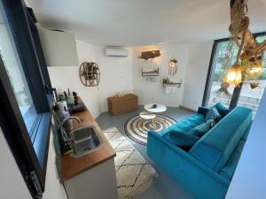 a living room with a blue couch and a table at Le Clos des Elfes in Saint-Martin-de-Londres