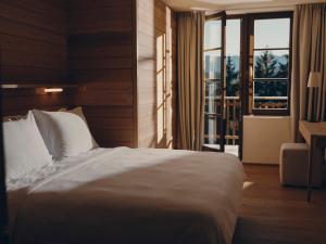 Un dormitorio con una cama blanca y un balcón. en Forestis Dolomites, en Bresanona 34 fotos más