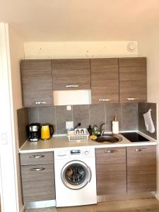 a kitchen with a washing machine and a sink at Seebrise in Wendtorf